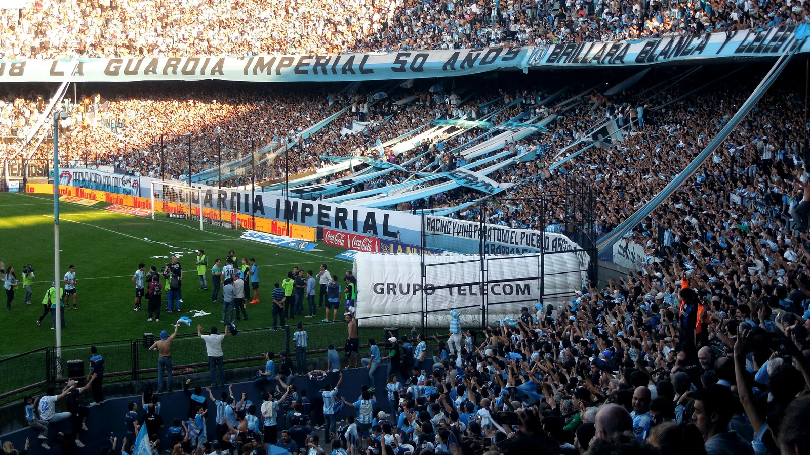 Argentina supporters waving the light-blue and white flag in a packed stadium — the defending champions' bracket path runs Kansas City to Miami to Atlanta and back to Arrowhead for the July 11 quarter-final