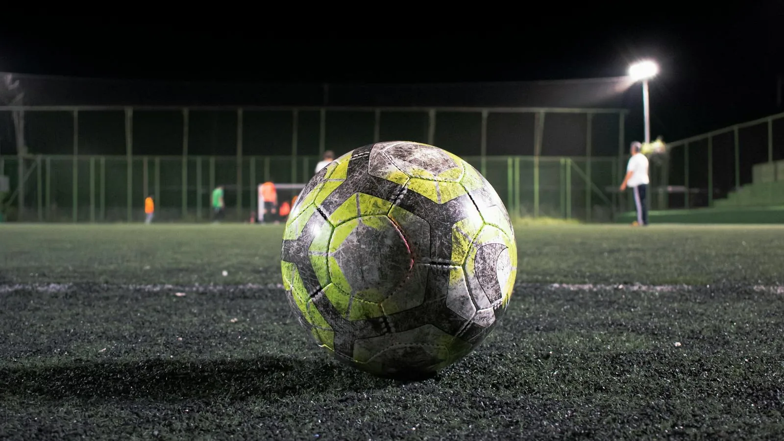 Football resting on floodlit pitch at night — UCL semi-final first leg between Atletico Madrid and Arsenal on April 29 with seven World Cup 2026 starters in action