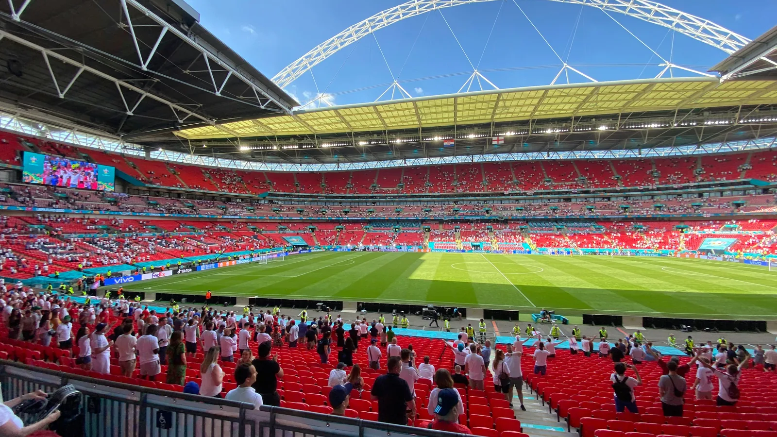 England supporters in red and white wearing Nike home jerseys at a tournament match — the 2026 home shirt sticks to the white-with-three-lions formula, with red as the away