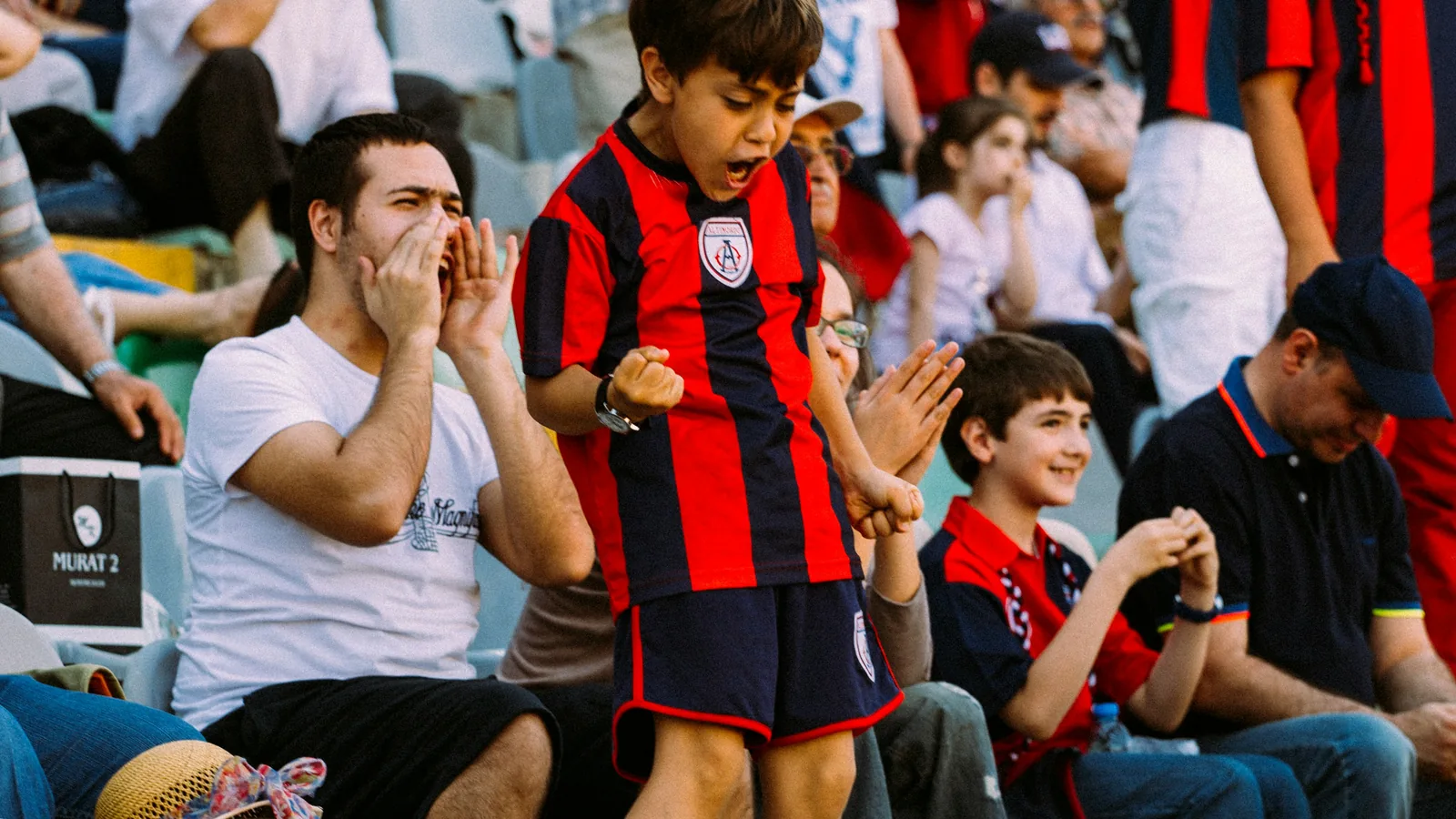Fans in national-team jerseys celebrating at night during a major tournament — the visual context for World Cup 2026 jersey demand peaks across launch month