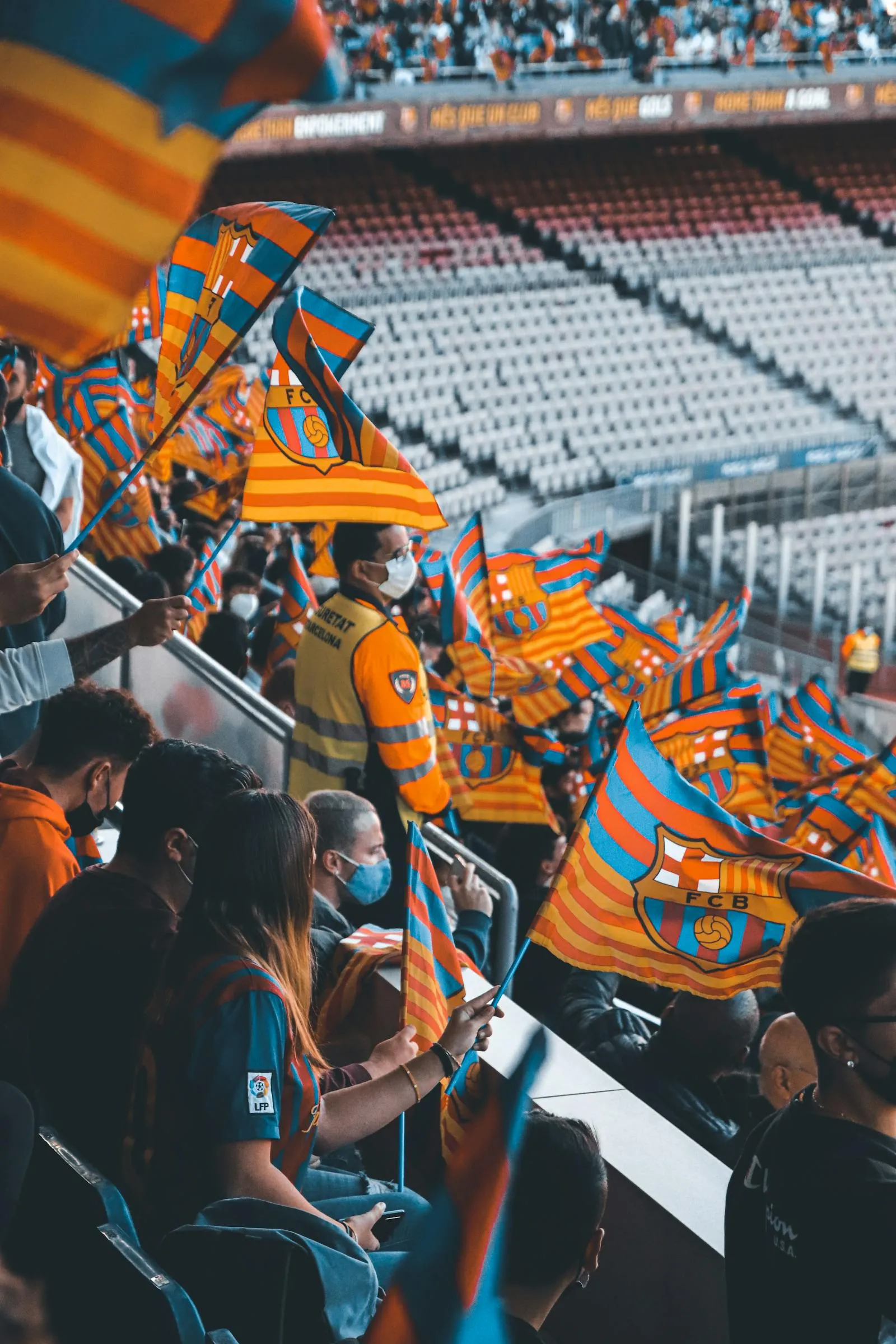 Fans waving flags in a packed stadium - World Cup songs and tournament memory