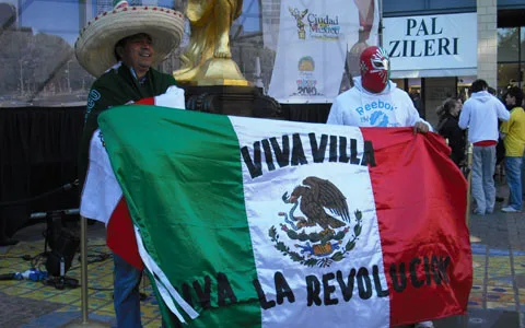 Mexico fans in green jerseys waving flags before an El Tri World Cup 2026 match at Estadio Azteca